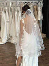 bride wearing tulle veil and flowing white slip dress in studio