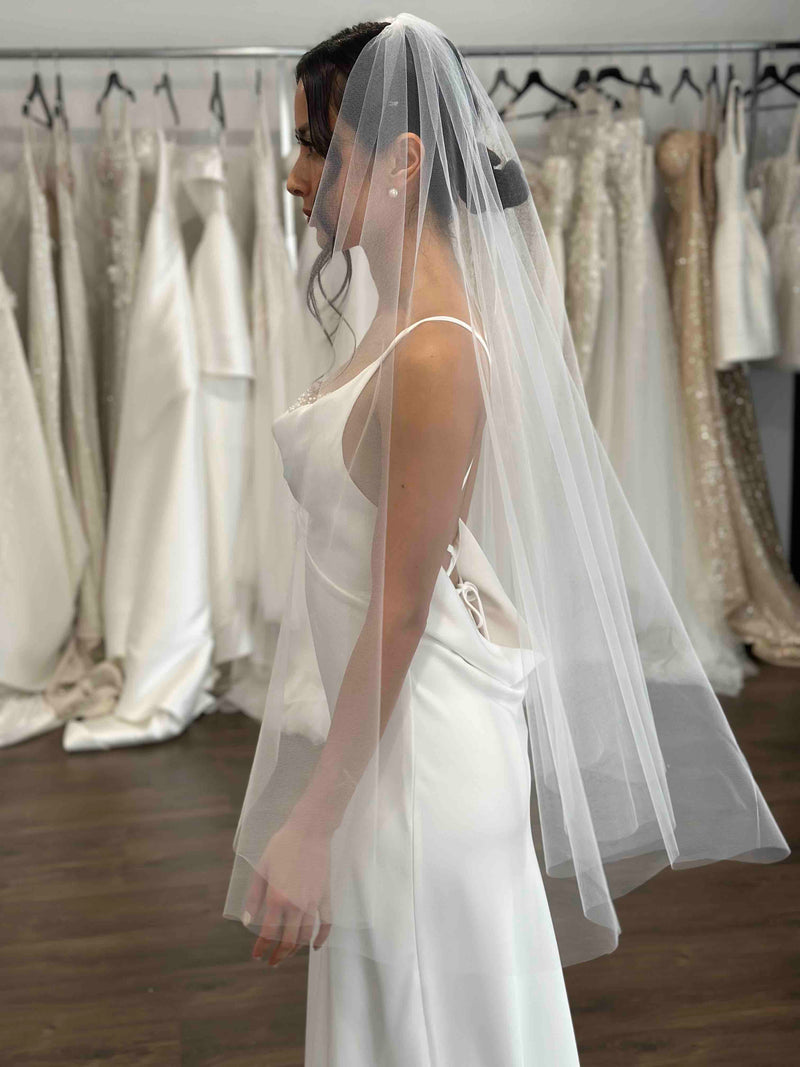 bride wearing wedding dress and veil in showroom
