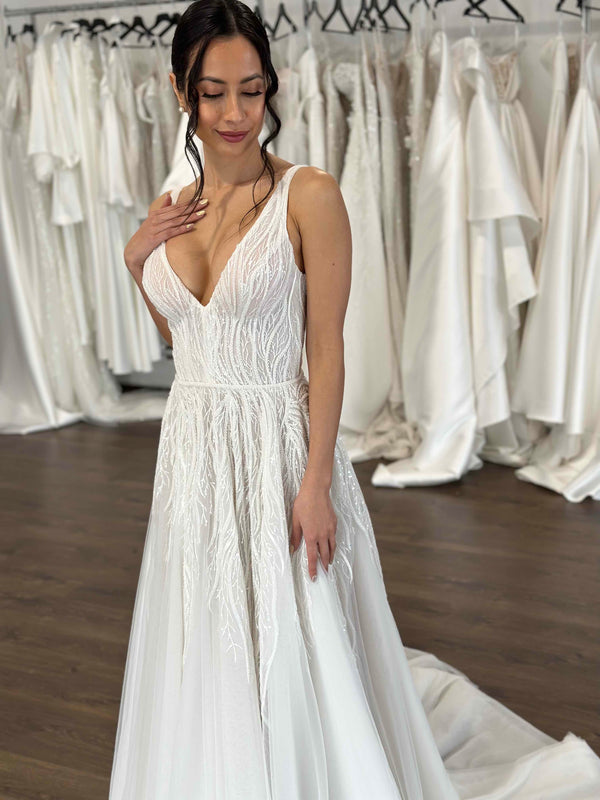 bride wearing white lace wedding dress with thin shoulder straps and v-neck