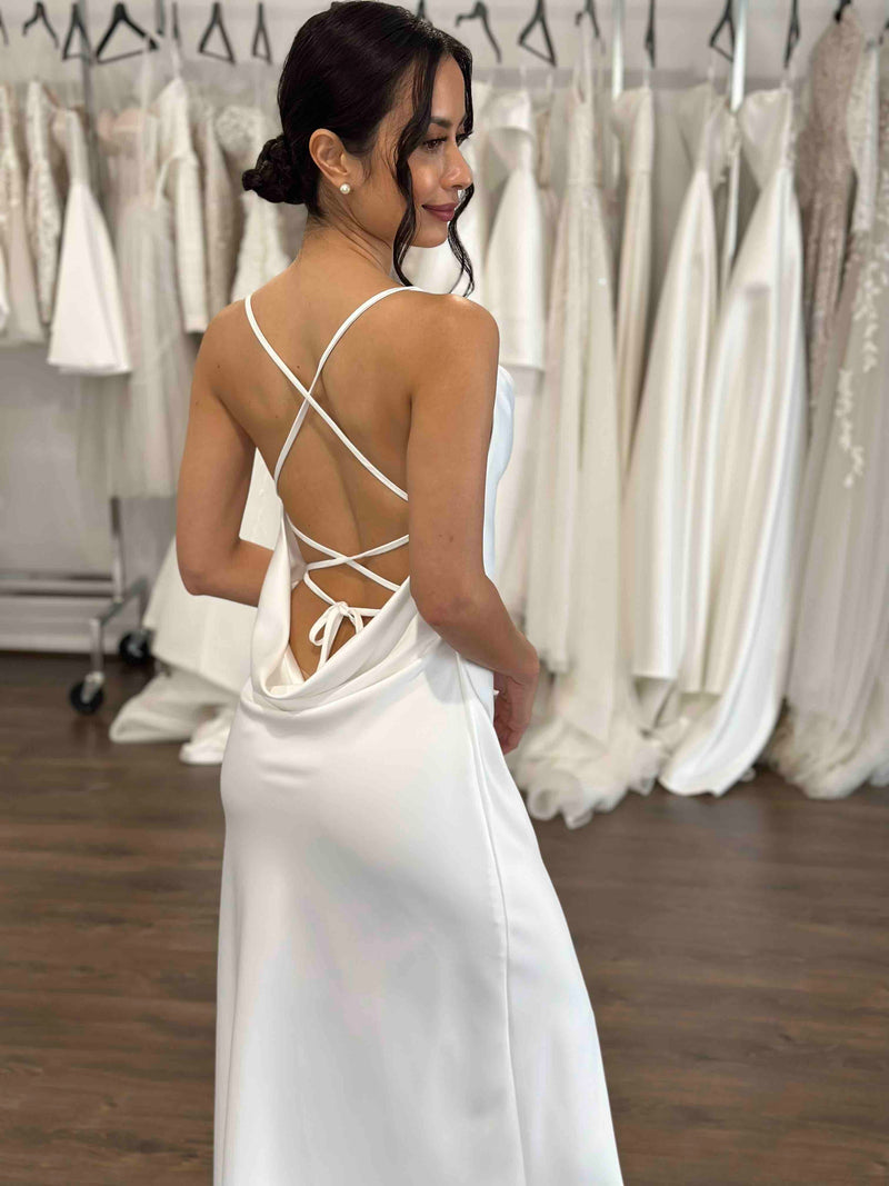 bride wearing white slip dress with cowl back and cross back ties
