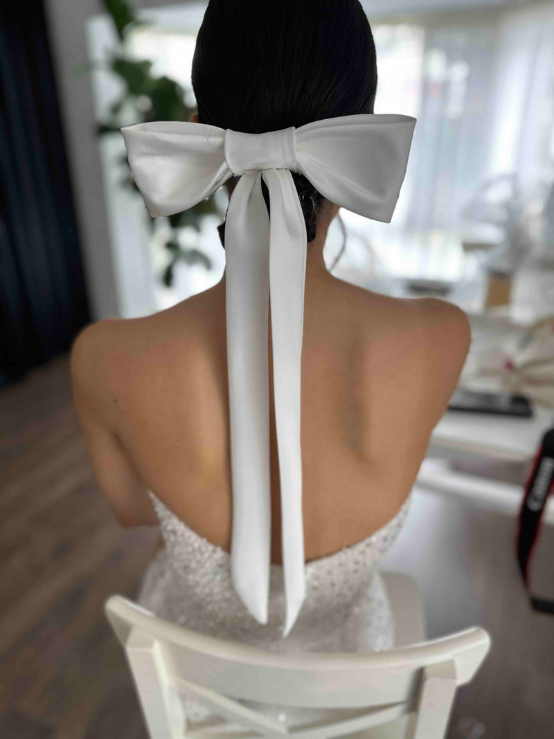 bride with bow tie clipped into her hair