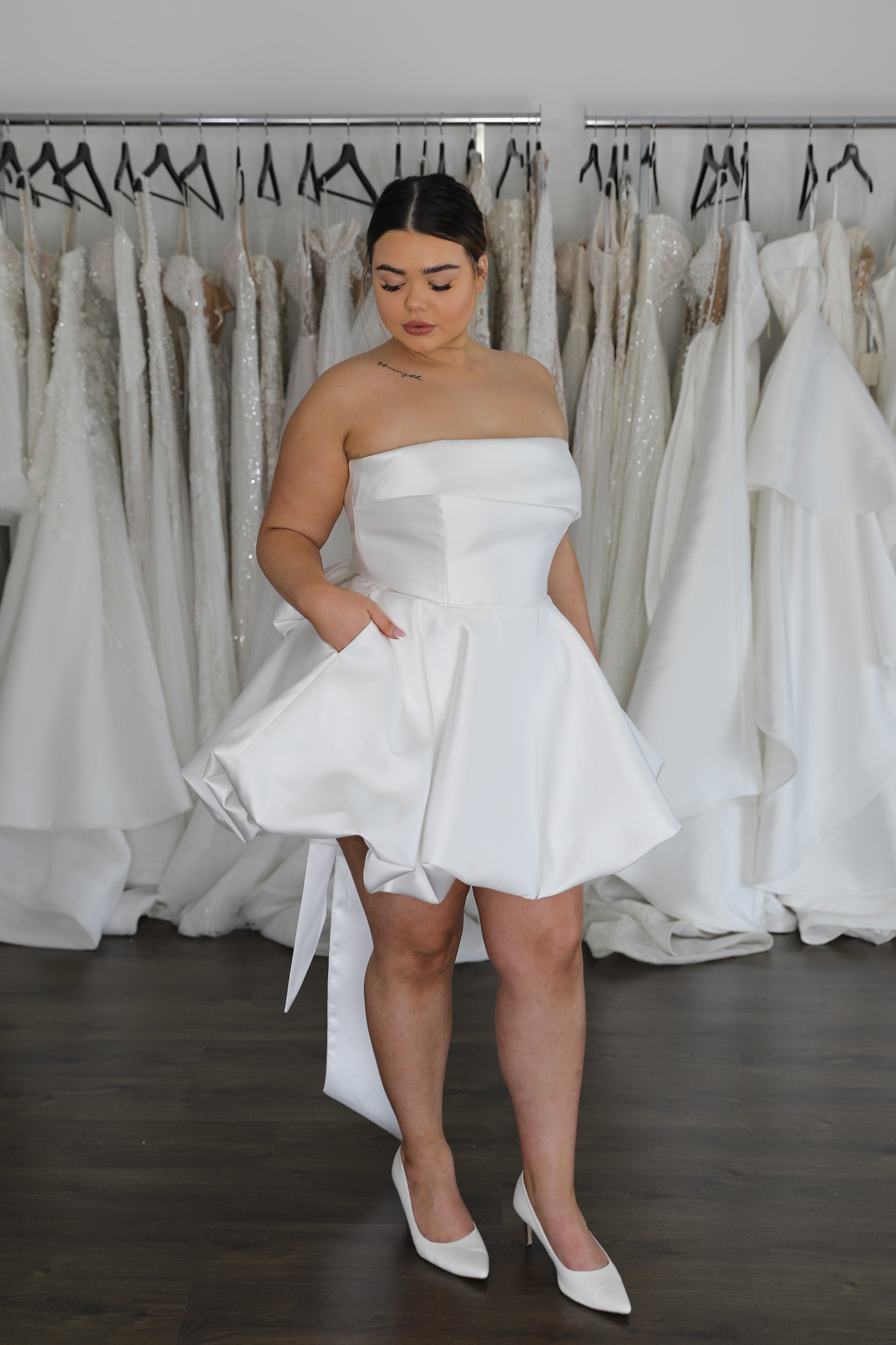 bride with hands in pockets of bubble hem mini dress