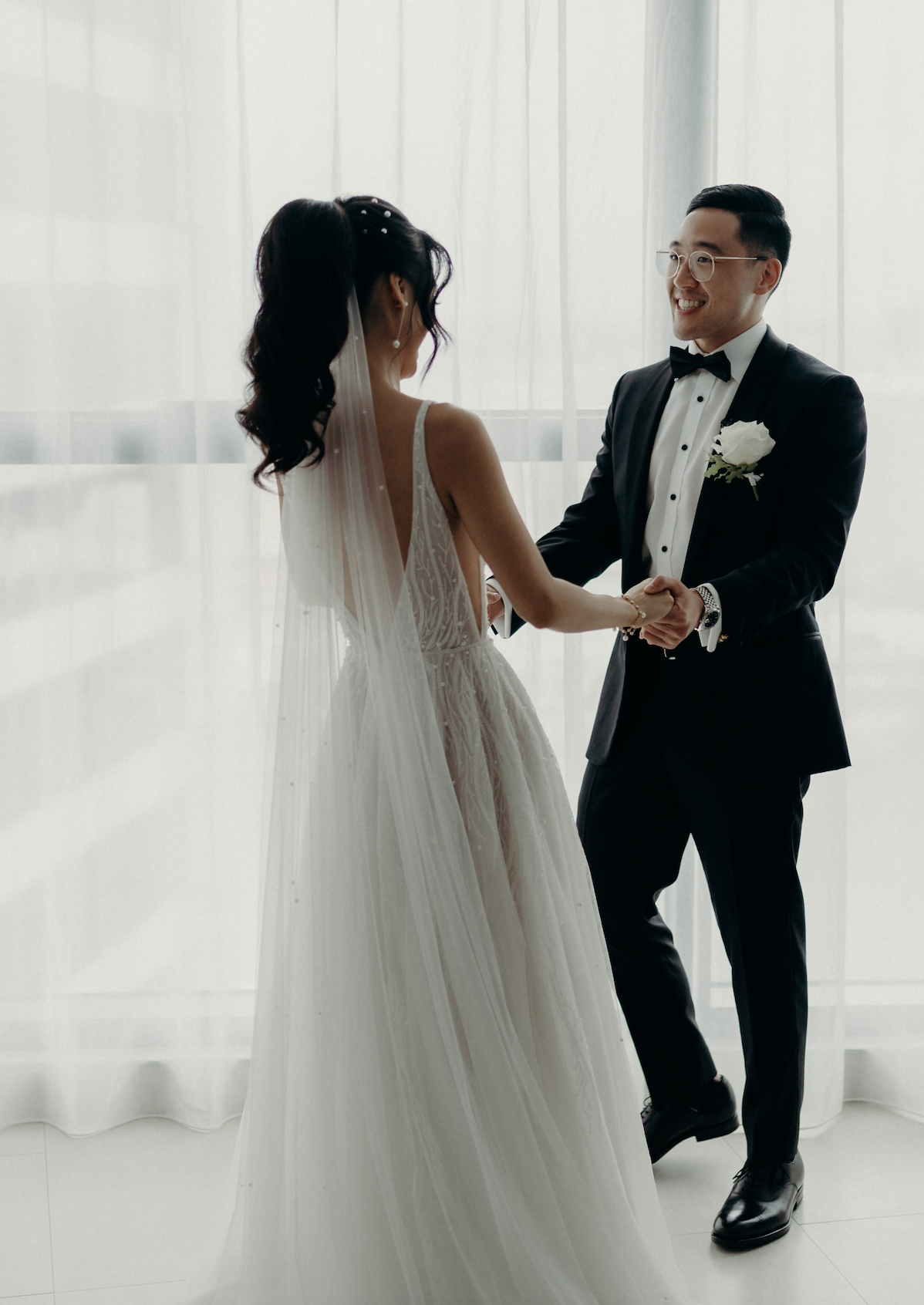 husband and wife holding hands in wedding attire