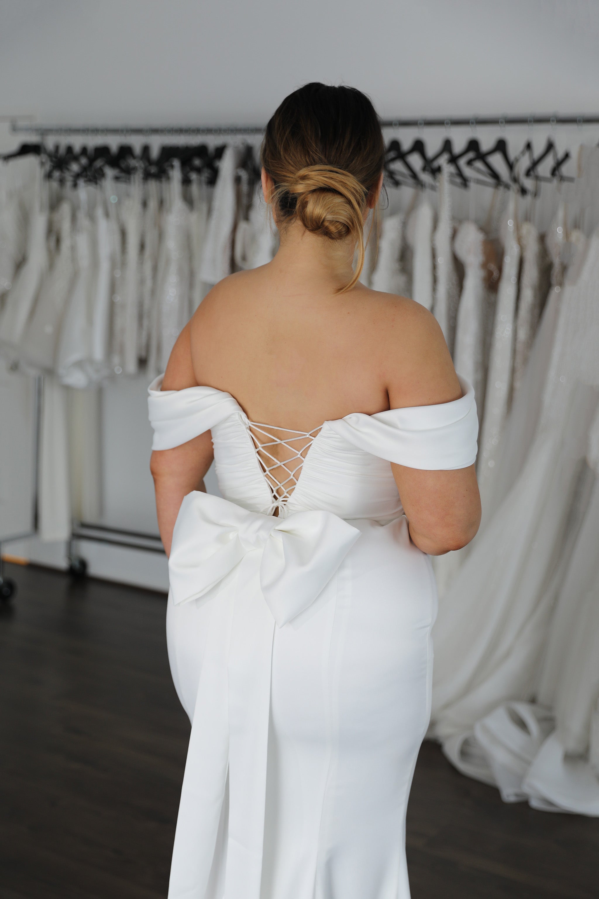 lace up back and off the shoulder sleeves with small white bow on dress