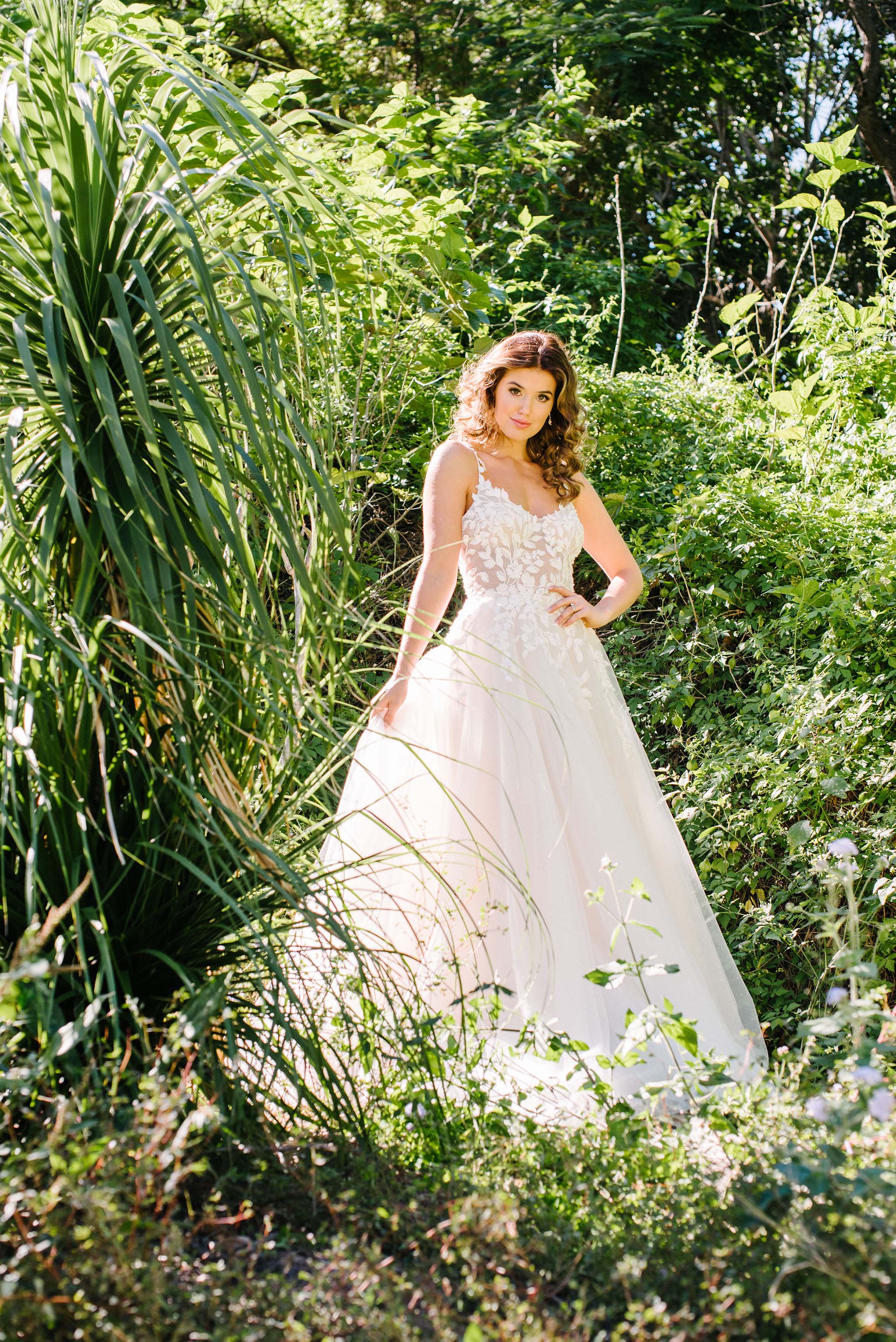 lace wedding dress on bride standing in green garden