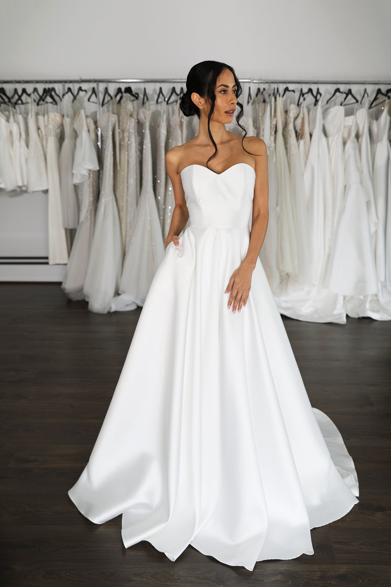 model posing in wedding gown with hand in pocket