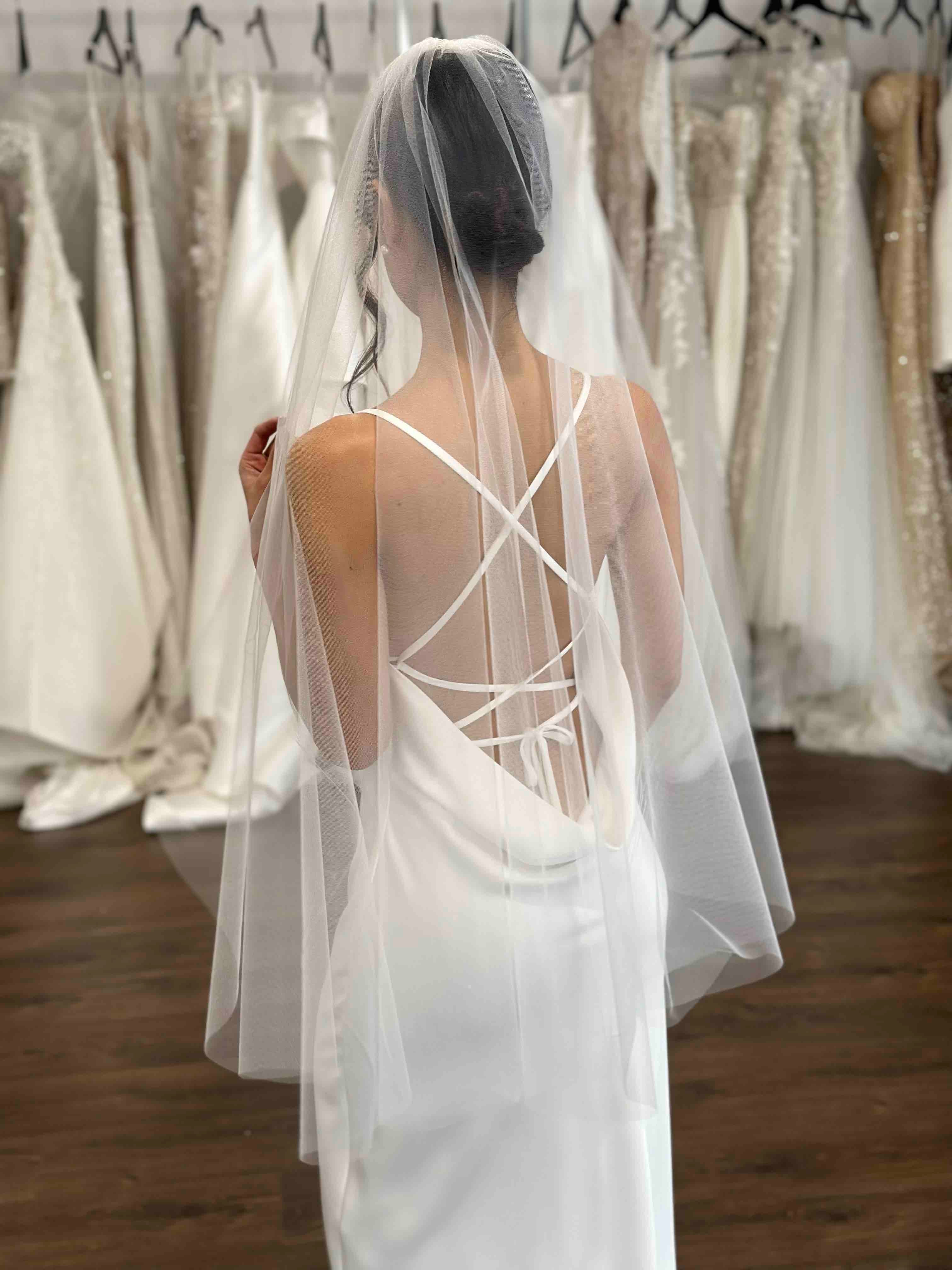 slip dress with cowl back and cross back tie-ups and short tulle veil on bride