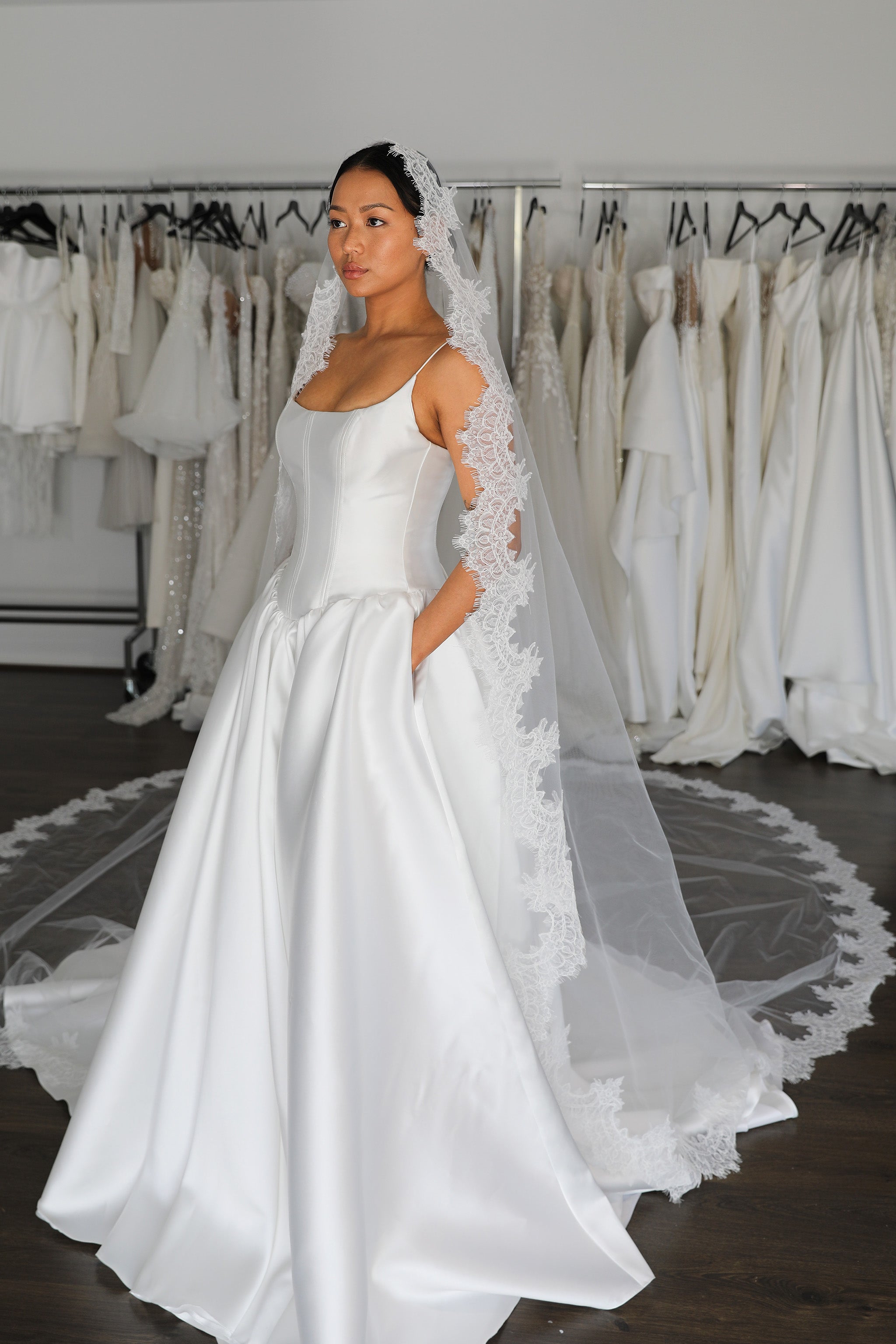 thin straps and drop waist mikado wedding gown on bride wearing veil