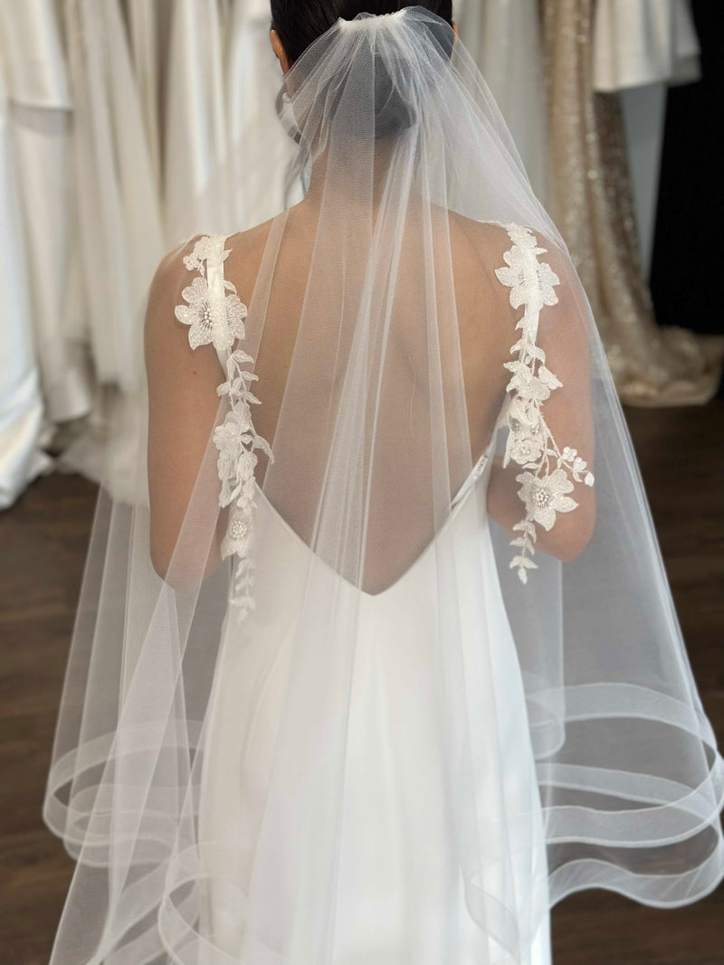 tulle veil and floral strapped white gown on model