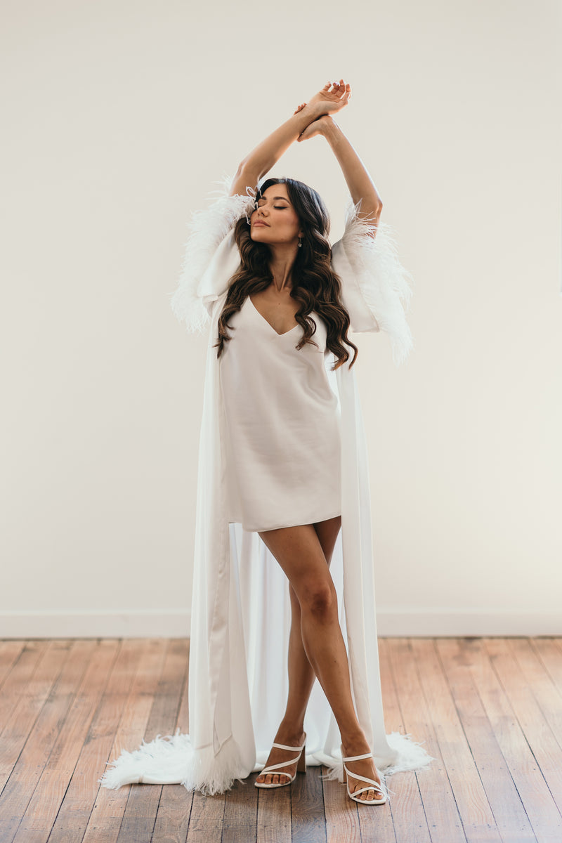 white bridal slip and long flowing feather robe on bride