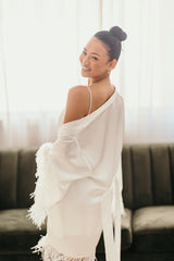 white robe hanging off brides shoulder