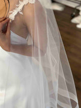 white tulle veil on woman's shoulder
