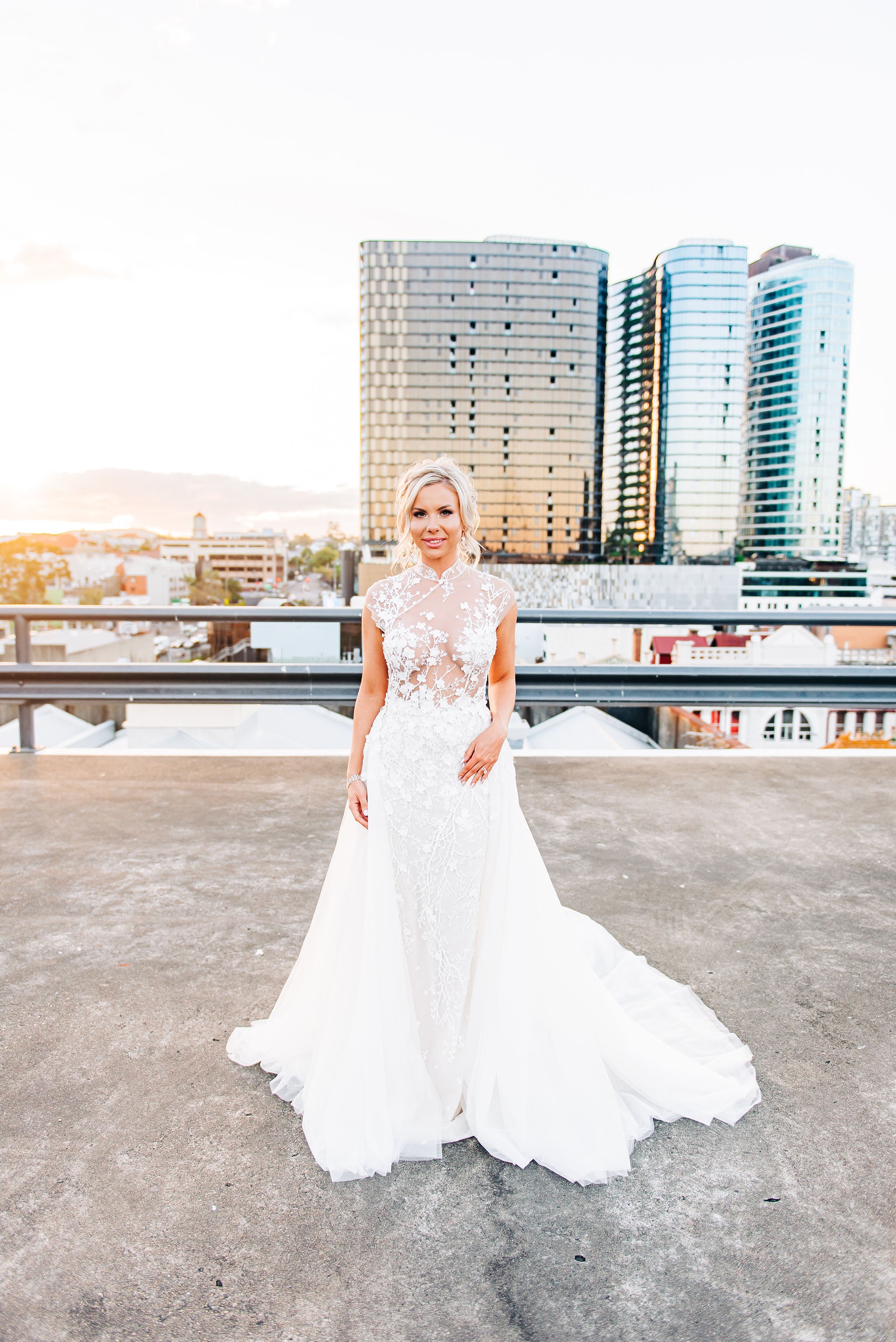 woman in wedding dress walking along rooftop at sunset