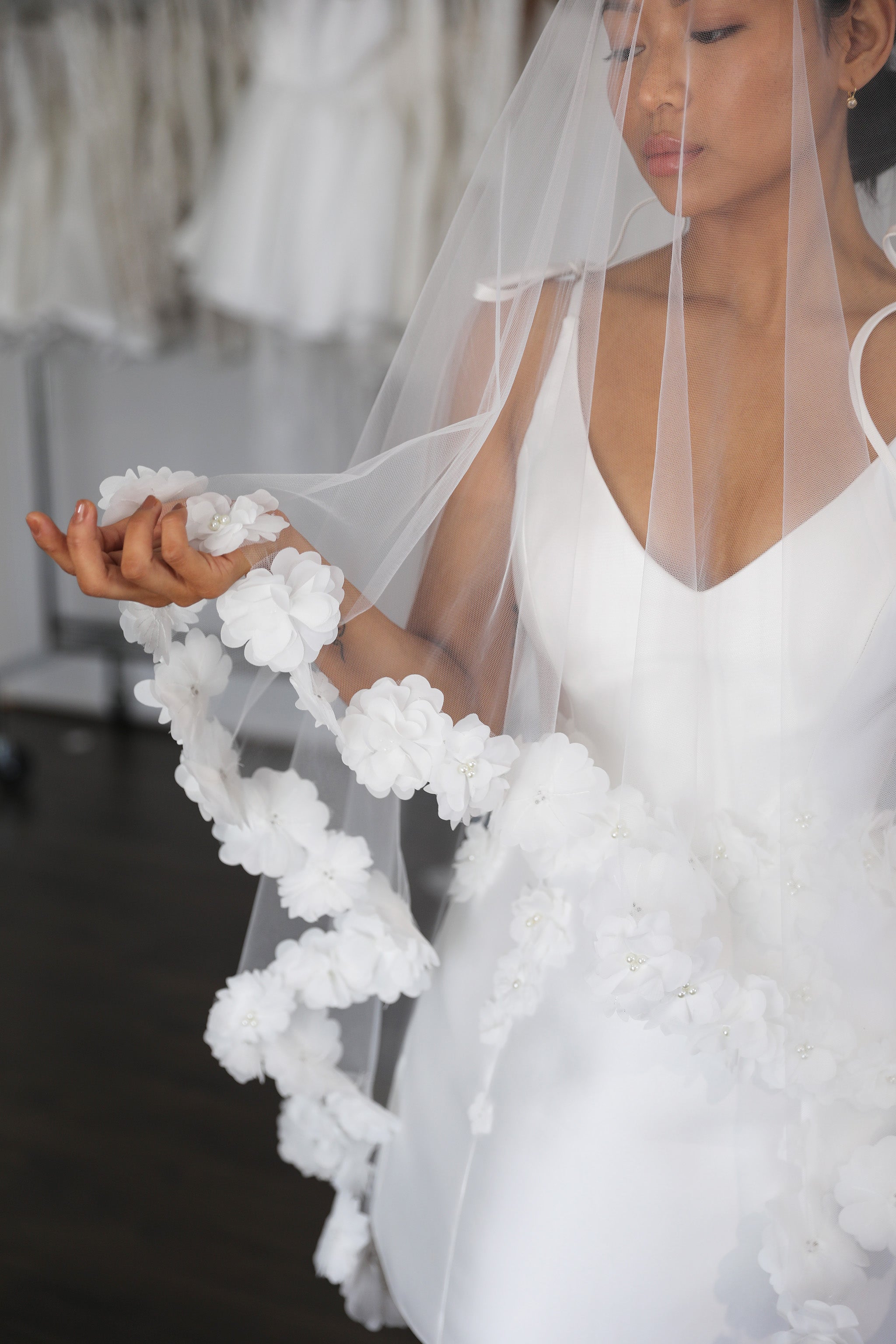 woman playfully holding floral appliqué veil