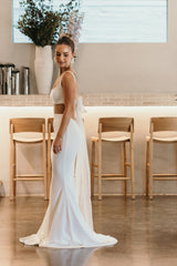 woman standing in front of chairs at wedding venue in white gown