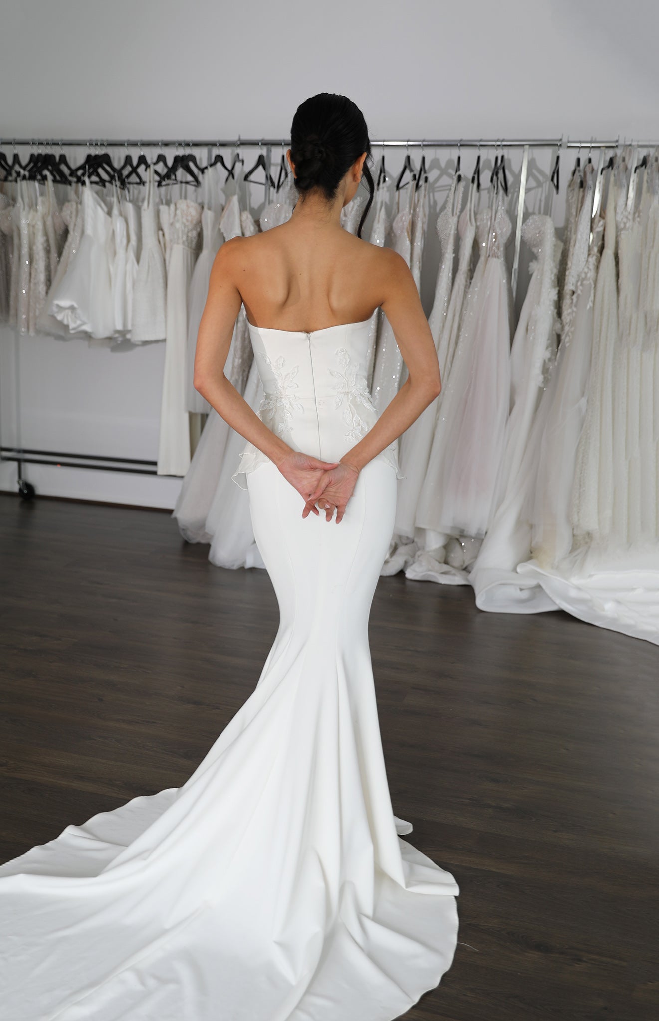 woman with hands behind her back in wedding dress
