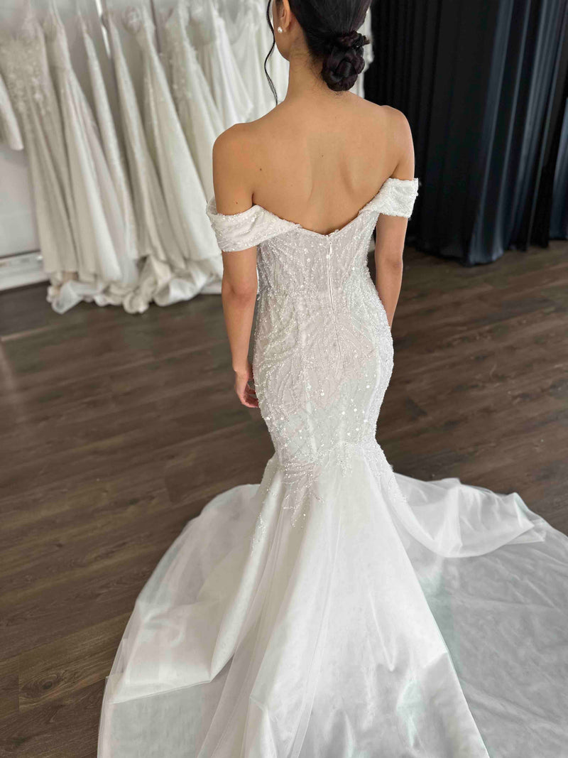woman's back in strapless wedding dress in showroom