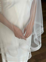 woman's hands under tulle veil with crinoline hem