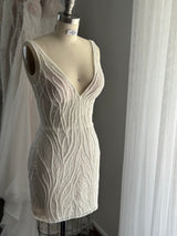 beaded vine lace wedding dress on dress form in front of other gowns
