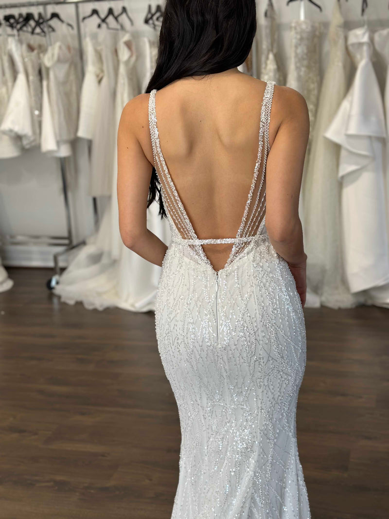 bride posing the back of her wedding dress at bridal boutique