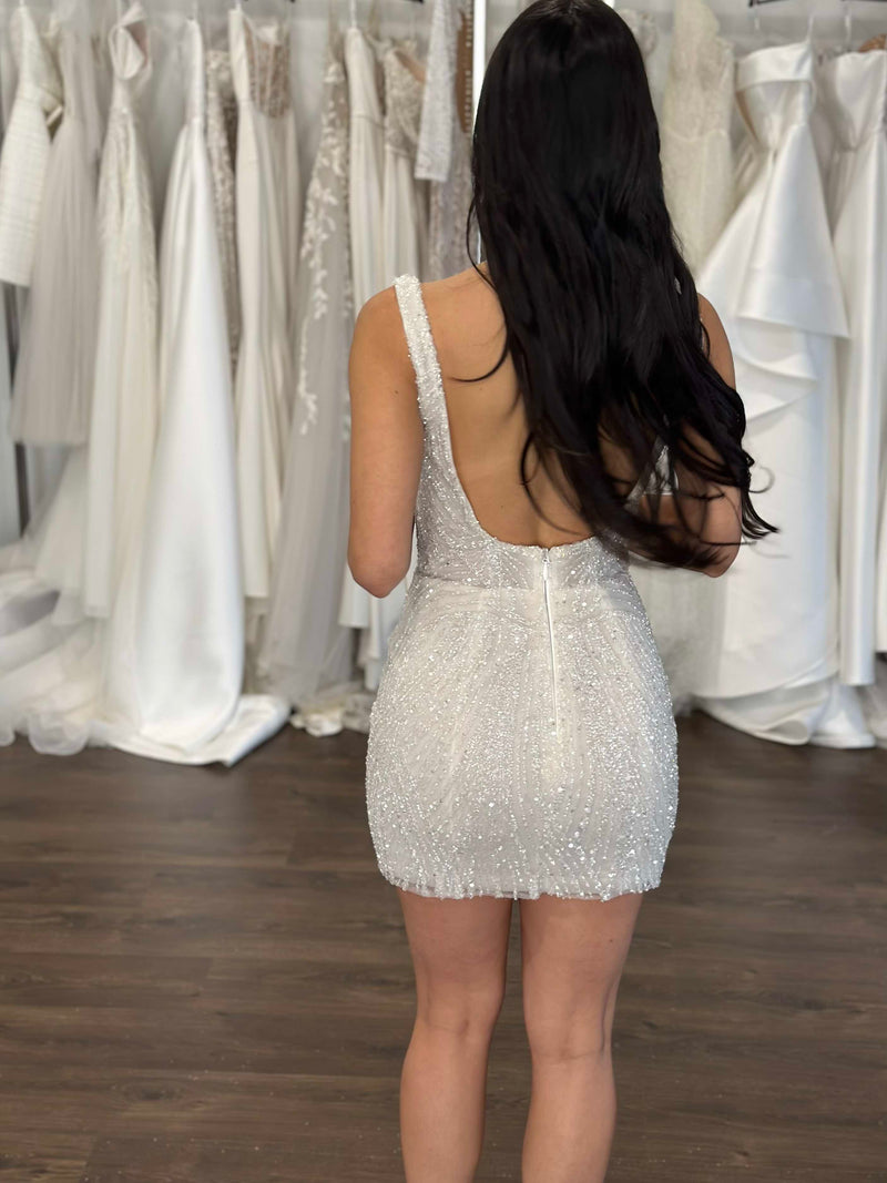 bride with long black hair wearing beaded lace gown at bridal store
