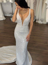 smiling woman running her hands through her hair wearing wedding gown