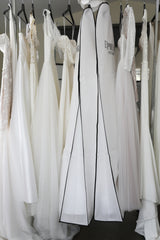 wedding dresses and garment bags hanging on clothing racks