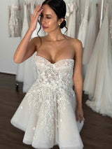 woman wearing white bridal mini dress made from tulle and flower lace